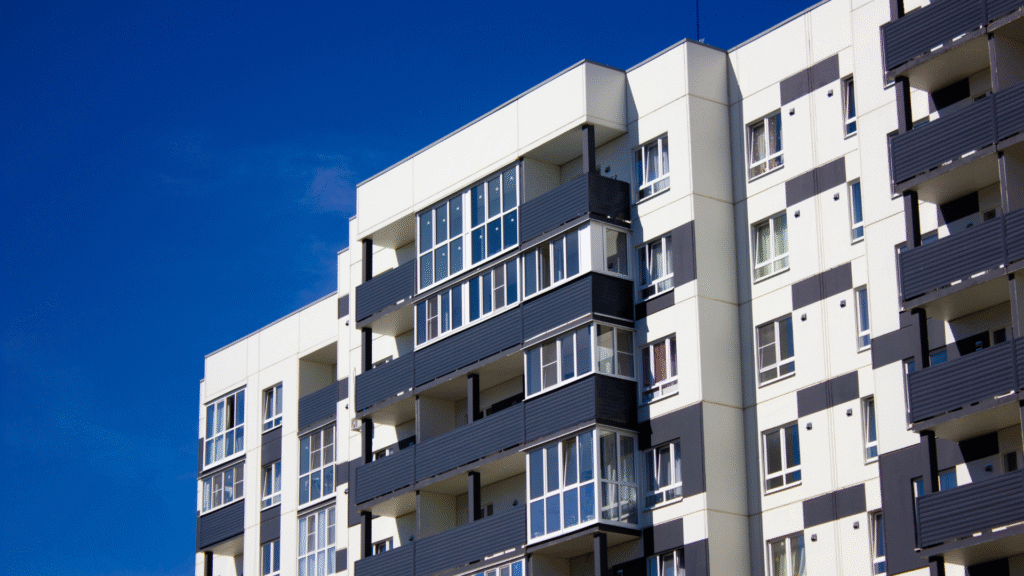 Modern apartment building with balconies under a clear blue sky.