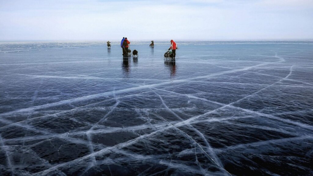 People standing outdoors in a snowy landscape during winter.