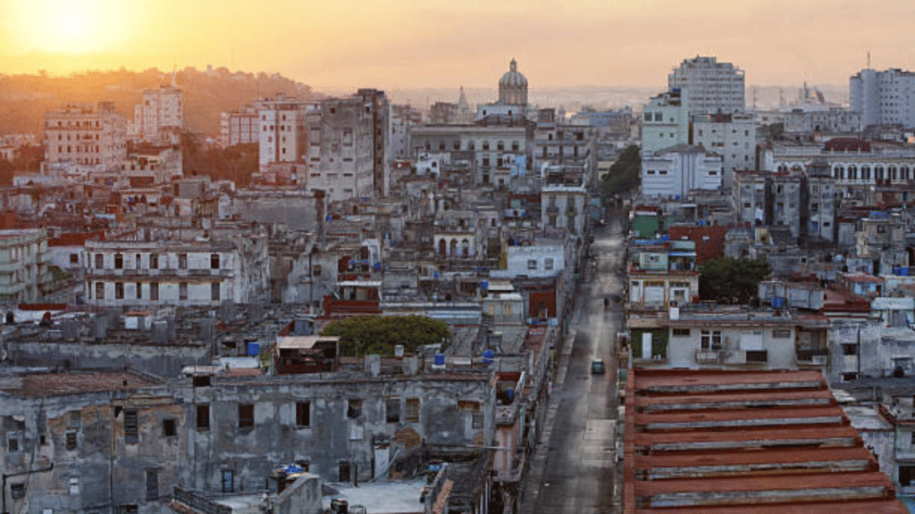 Aerial view of Havana skyline at sunset with historic buildings and a domed capitol in the distance.