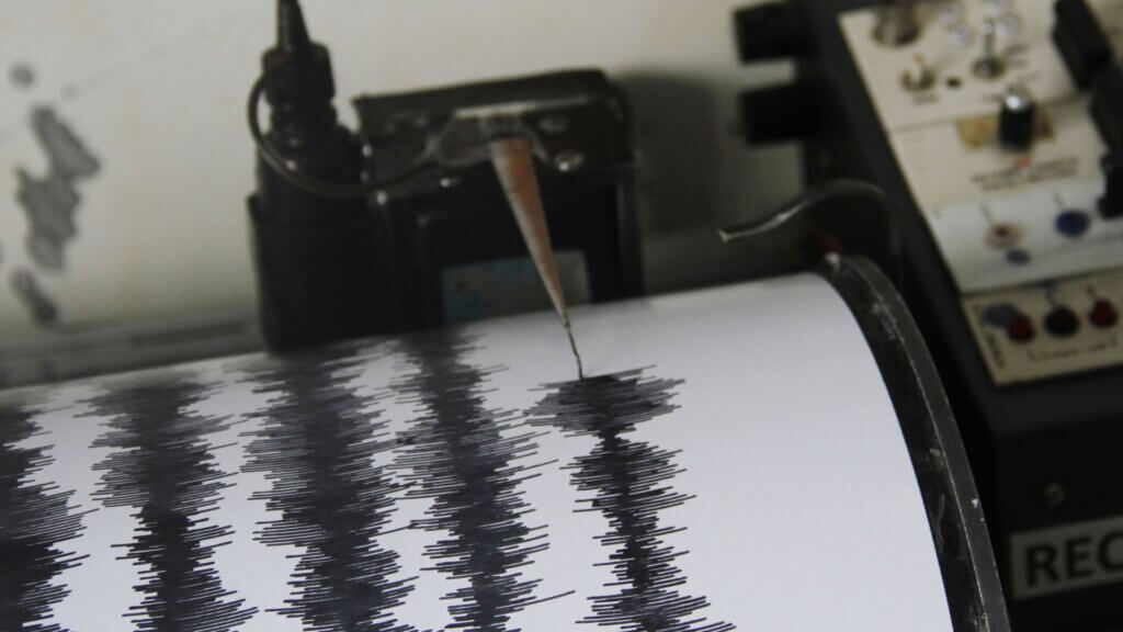 Seismograph instrument recording seismic activity on paper