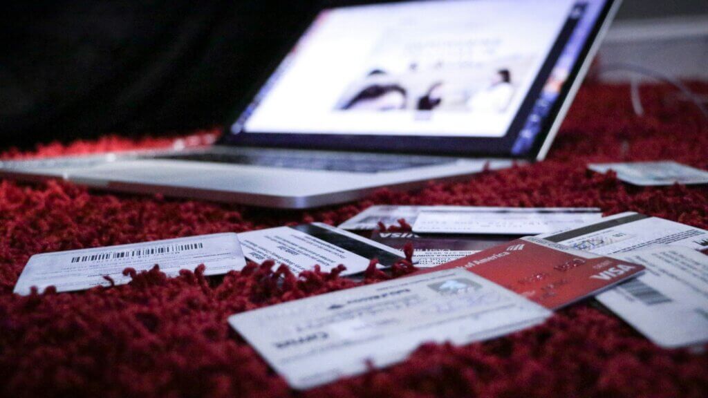 Credit cards and paper scattered across a red fabric surface
