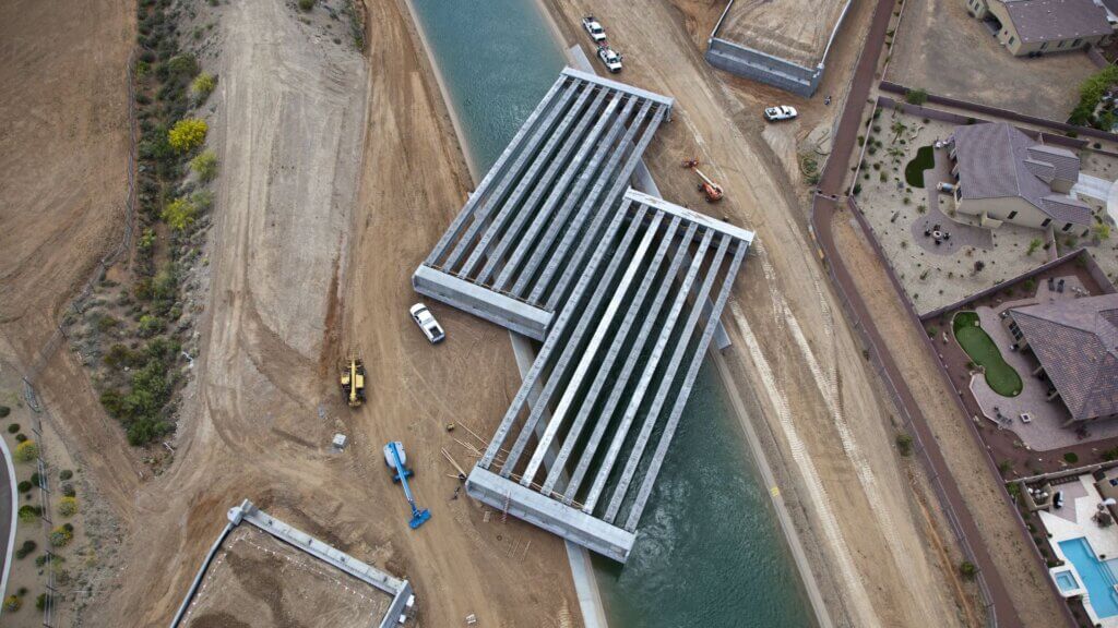 Bridge construction over a concrete-lined canal.