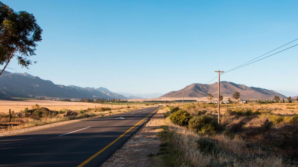 Long empty concrete road stretching across open terrain