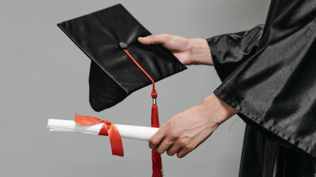 person holding diploma and graduation cap