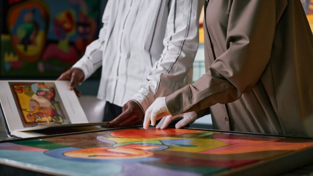Stock photo of hands observing art pieces at modern art gallery exhibit