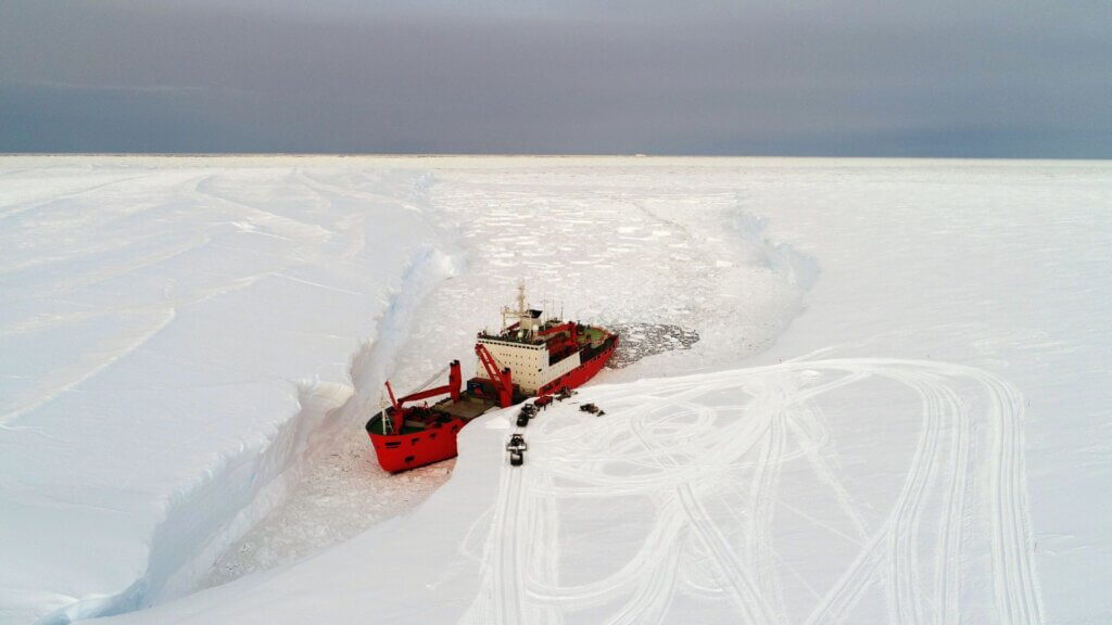 A cargo ship arrives in port for unloading on an ice floe in the Antarctic