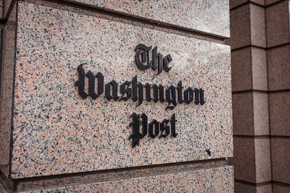 Closeup of The Washington Post newspaper logo sign on the facade of a building downtown Washington, DC