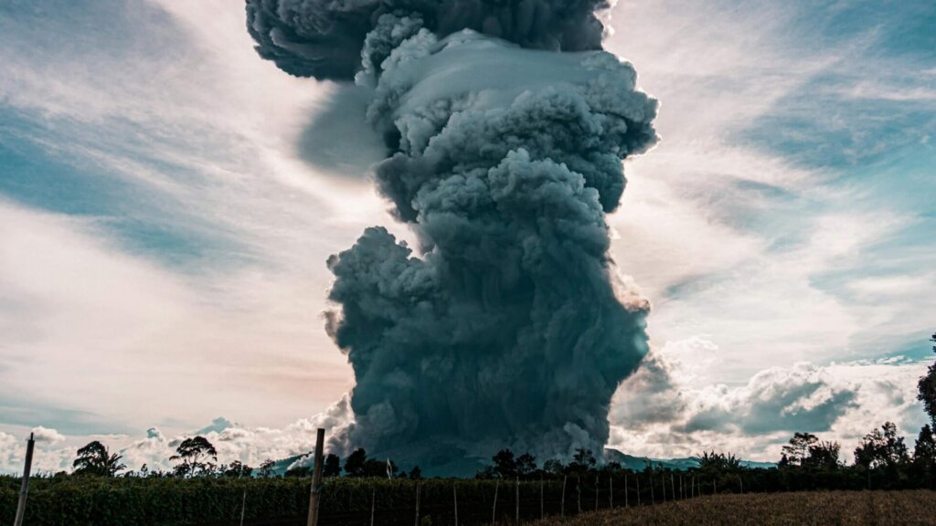 Gray smoke rising and swirling in the air against a dark background.