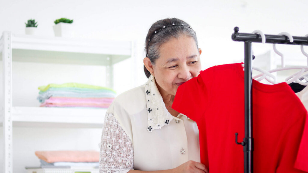 Smiling senior woman standing indoors at home.