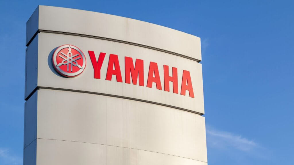 Yamaha logo displayed on corporate office building exterior against clear blue sky.