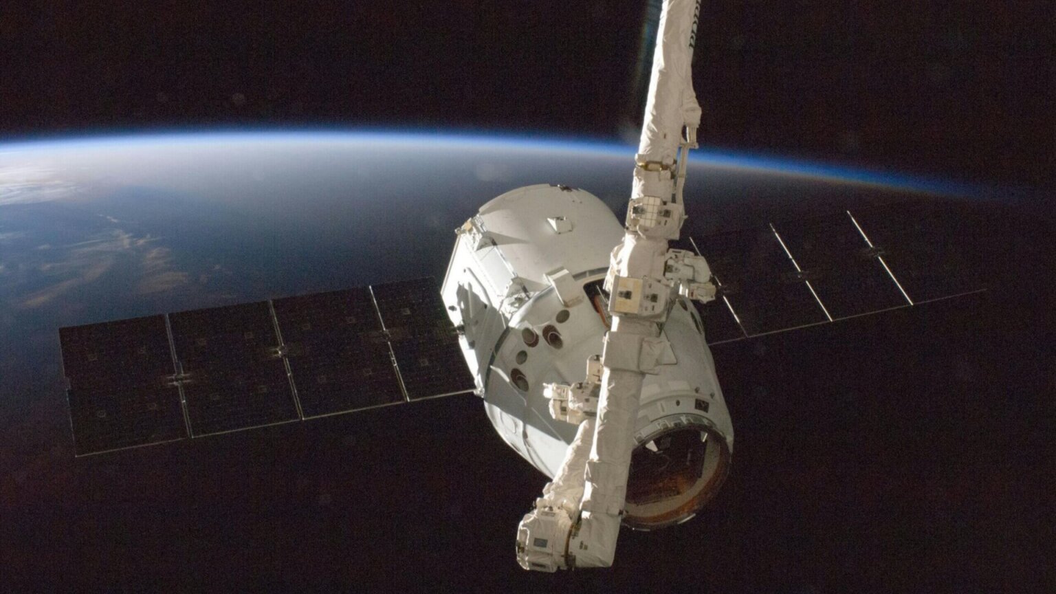 Defunct 1,300-Pound NASA Satellite Reenters Earth’s Atmosphere Over Pacific NASA space shuttle Discovery in orbit above Earth with blue atmosphere visible.