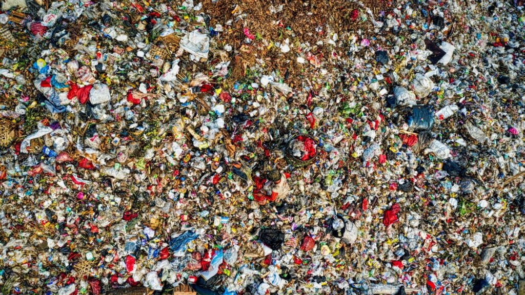 Close-up of mixed waste and debris piled together at a landfill.