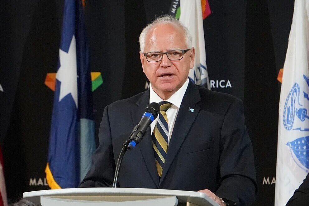Governor Tim Walz speaking at a podium during an event at the Mall of America.
