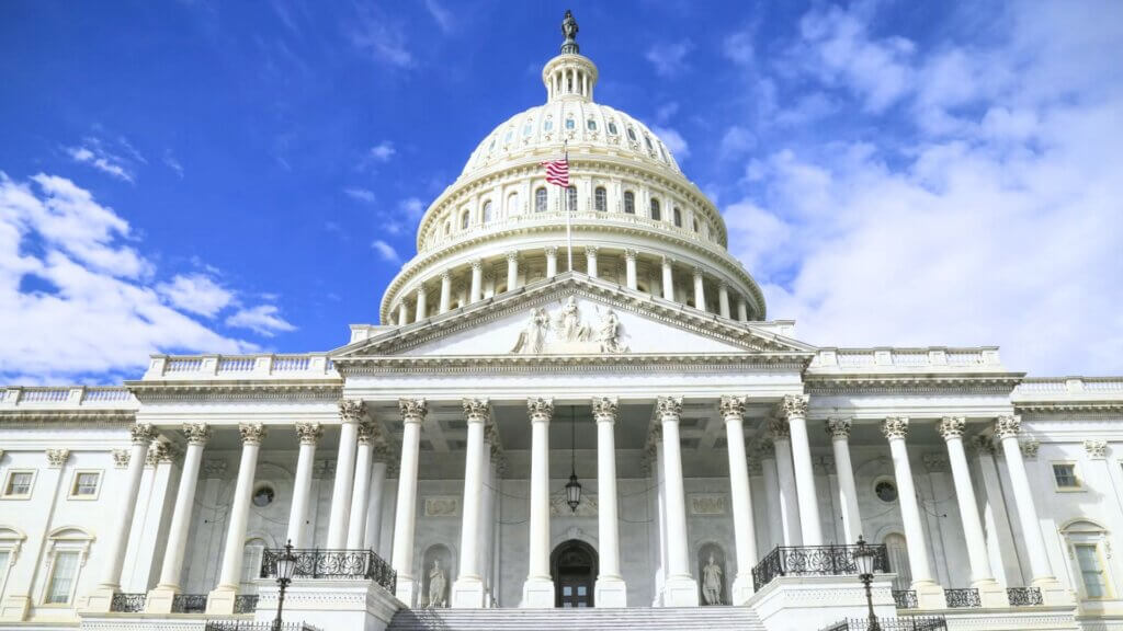 The United States Capitol building under a blue sky.