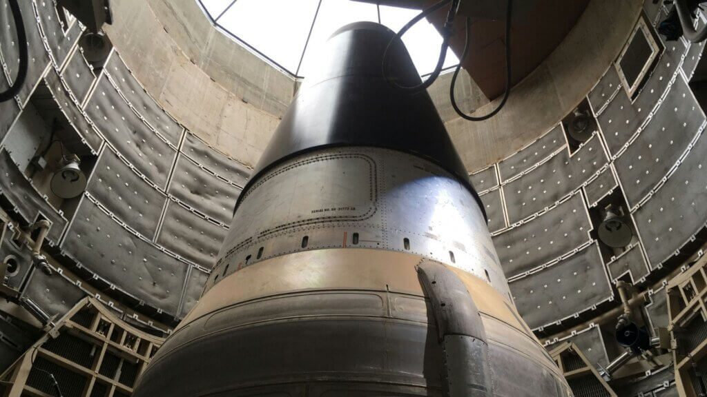 Intercontinental ballistic missile standing inside underground launch silo facility.