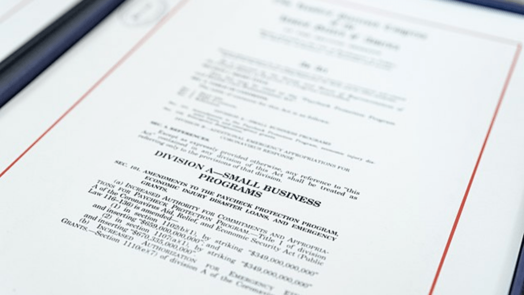 A close look shows a printed official document about small business programs.