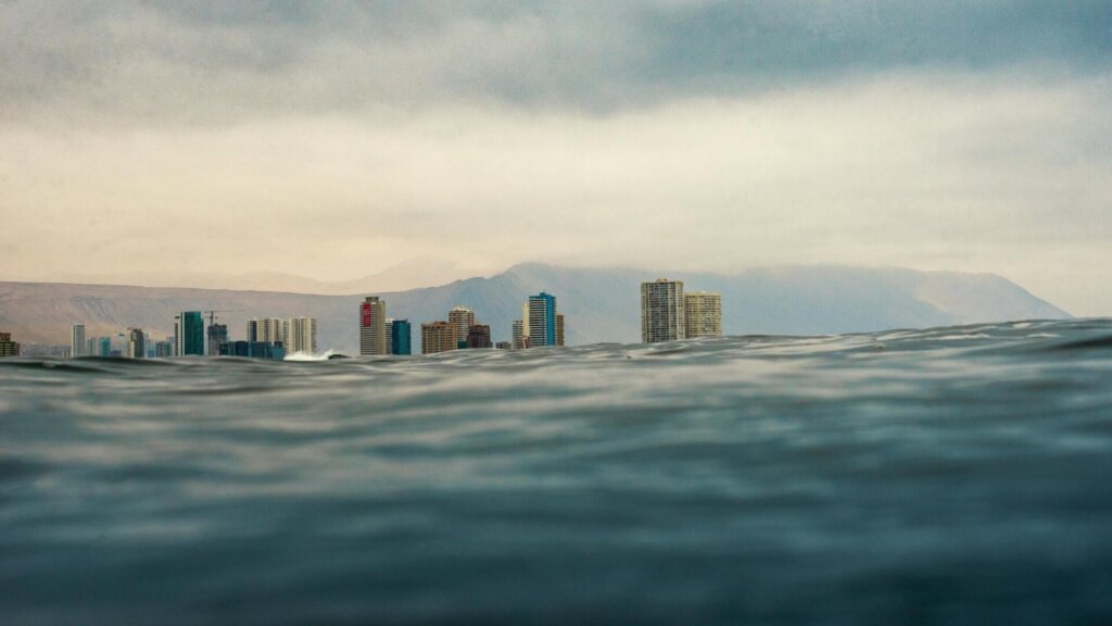 Modern city skyline reflected behind the ocean.