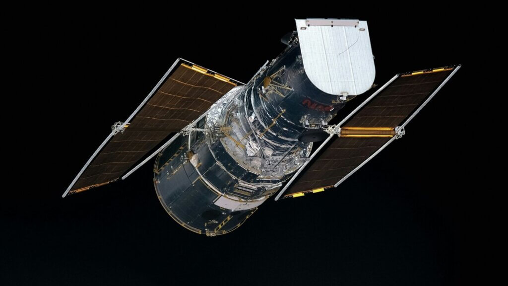 NASA Hubble Space Telescope floating in orbit with solar panels extended.