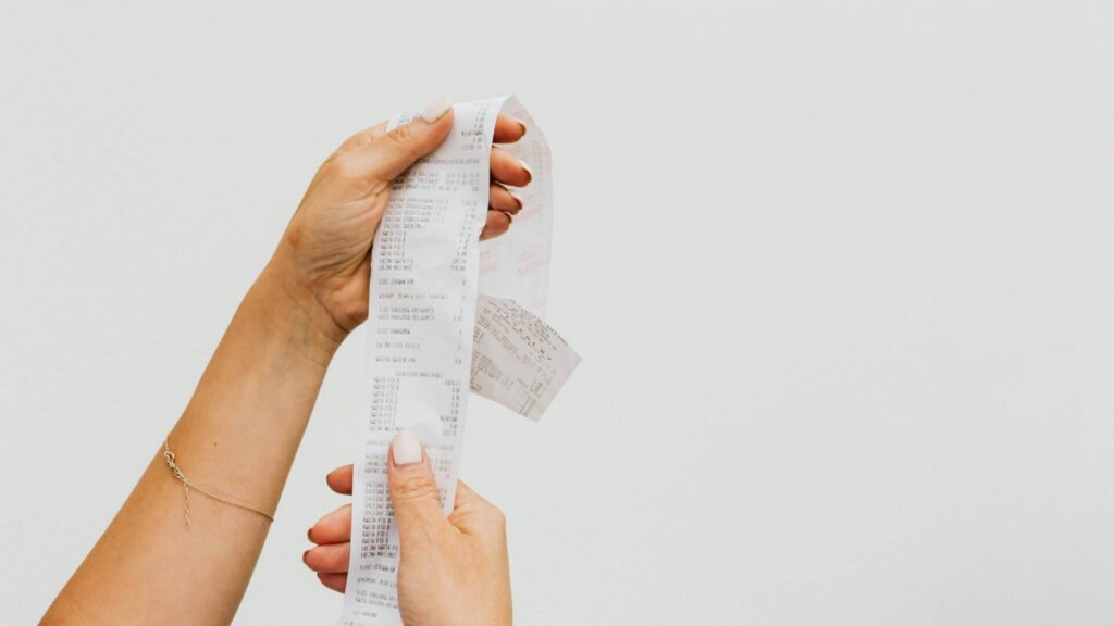 Person holding a printed receipt after making a purchase.