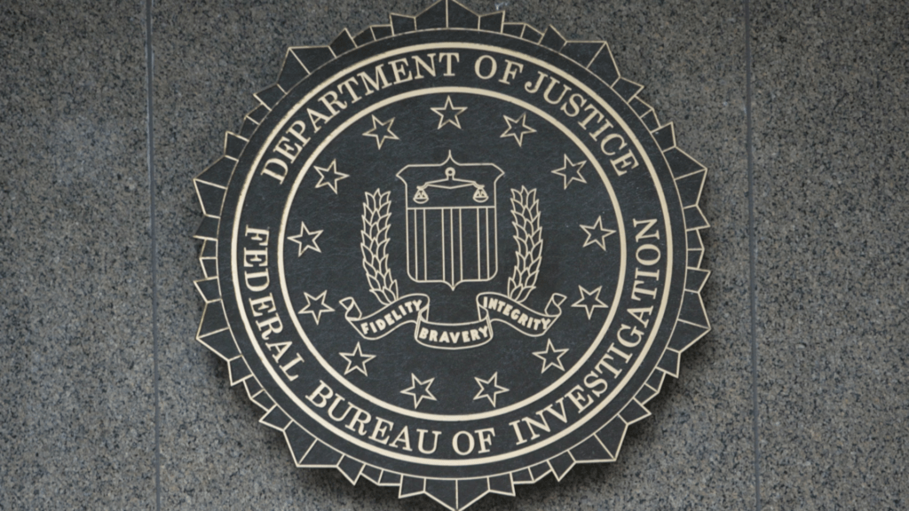 The round seal for the Federal Bureau of Investigation hangs on a stone wall.
