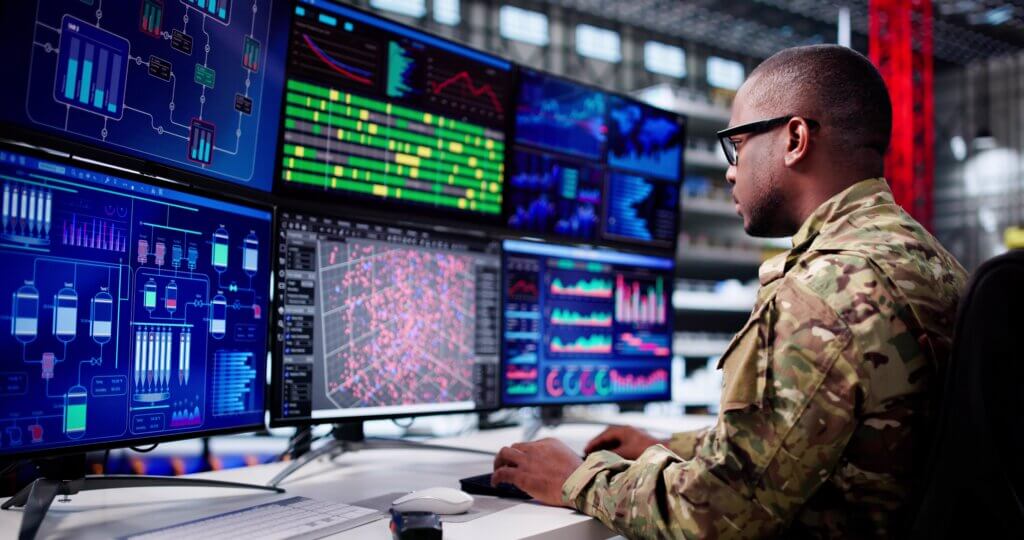 Engineer monitoring rocket assembly equipment inside a military facility.