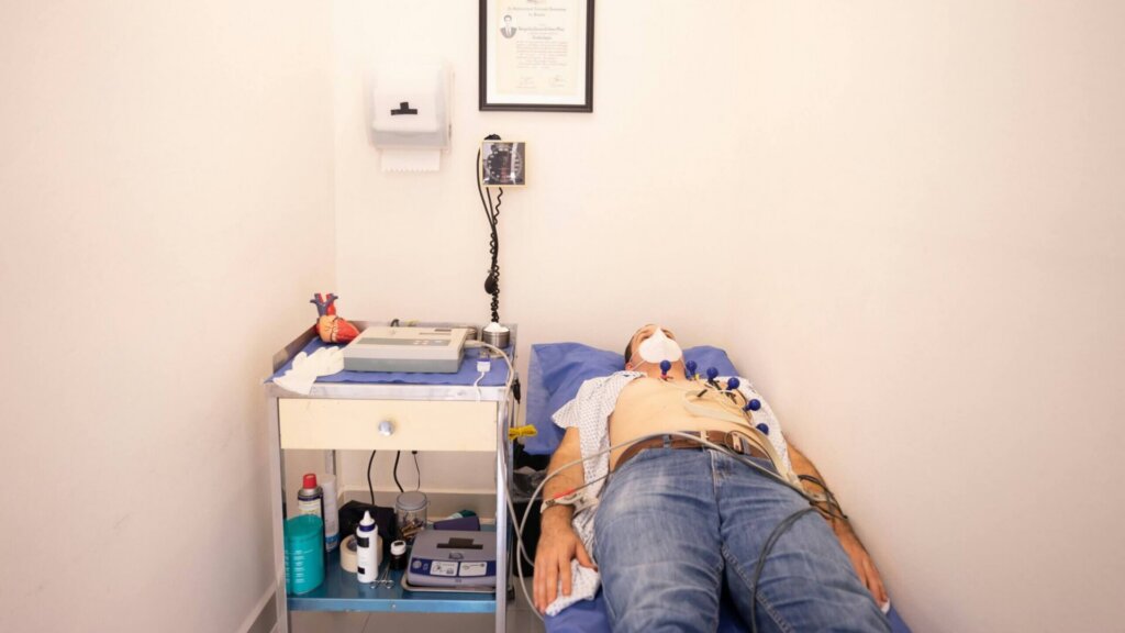 Patient lying on a hospital bed while undergoing an ECG heart test.