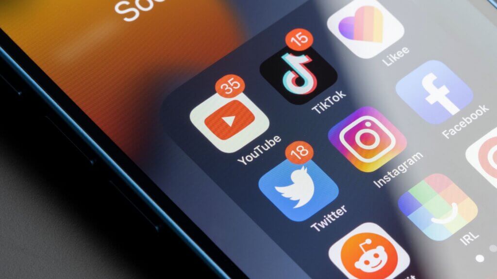 Smartphone screen displaying social media apps including YouTube and TikTok.