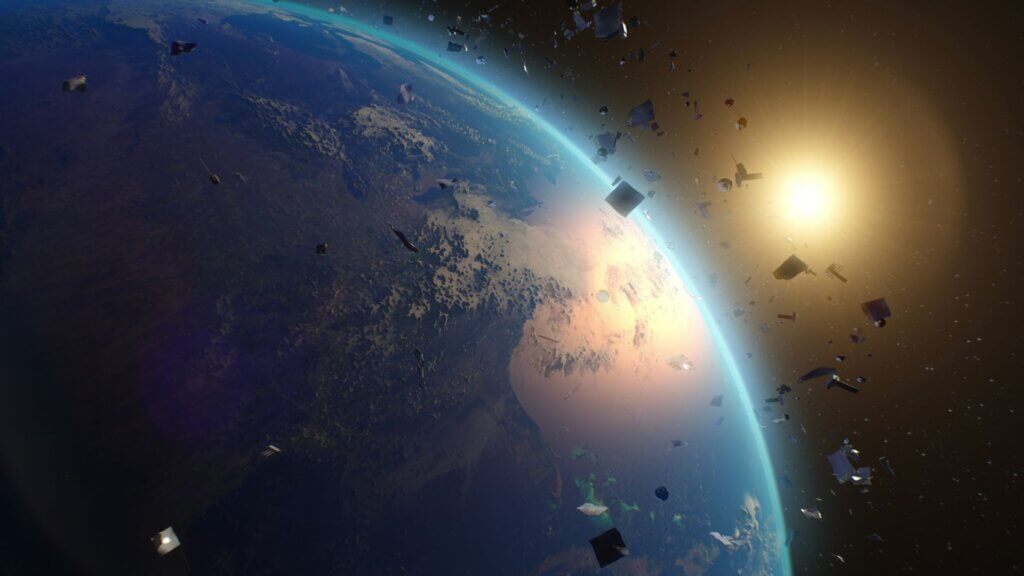 Space debris fragments orbiting Earth with sunlight illuminating the planet’s edge.