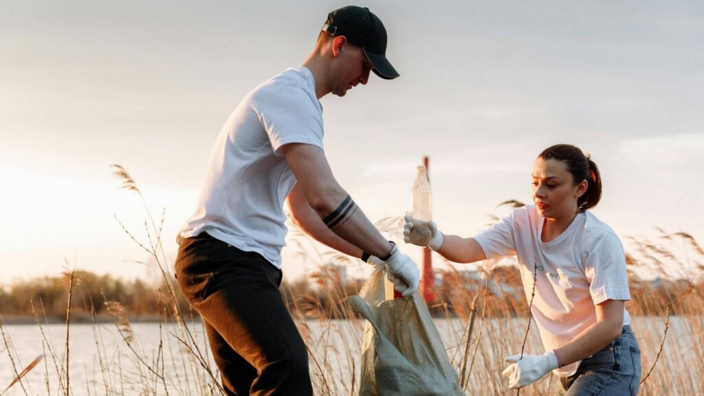 People collecting trash in a natural area during a cleanup effort.