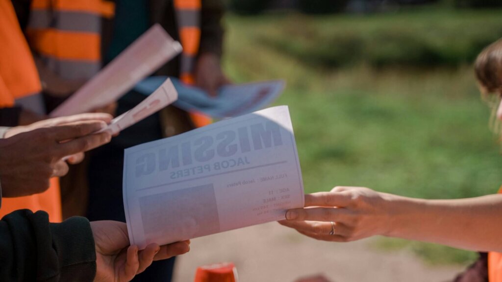 Person handing over a ballot envelope during a voting process.