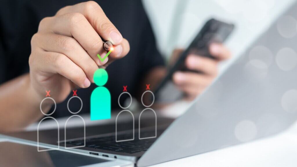 Hand selecting a digital candidate icon marked with a green check while other icons are crossed out