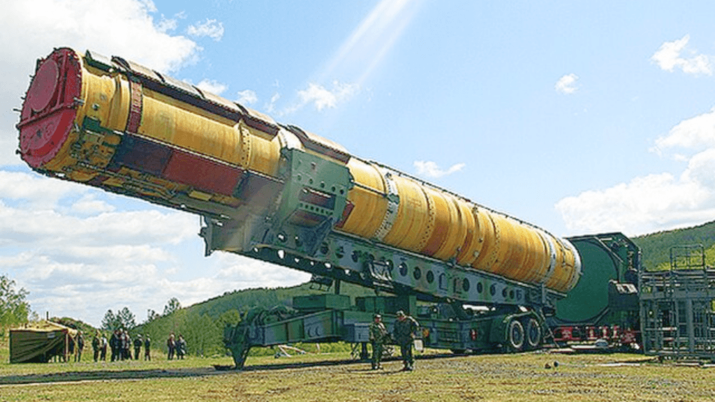 Large intercontinental ballistic missile mounted on a mobile launcher in an outdoor field.