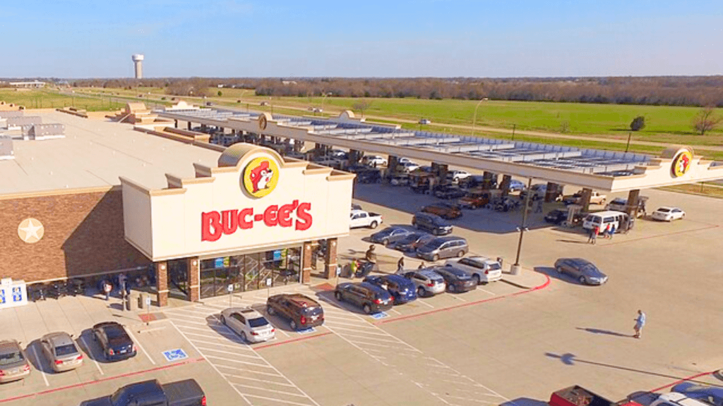 A high view shows a large Buc-ee's store and many busy gas pumps.