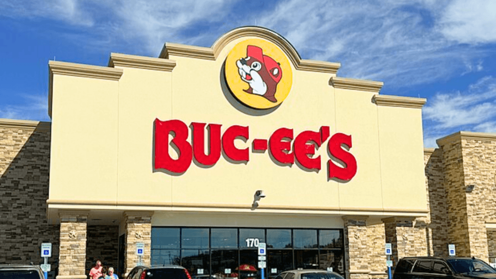 The front of a Buc-ee's store features a large red sign under a blue sky.