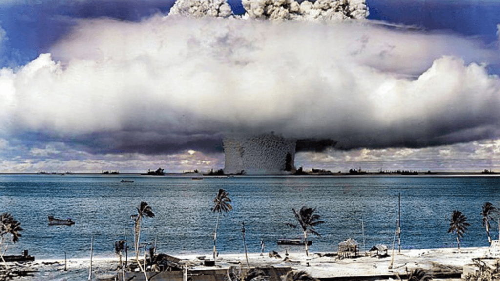 Massive mushroom cloud rising from a nuclear explosion over a coastal area.