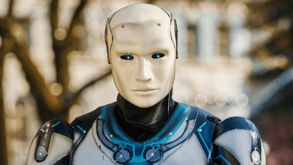 A robot with a smooth white face and glowing blue eyes stands outside.