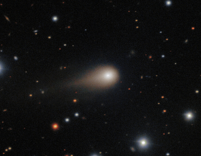 Comet with glowing tail moving through a star-filled sky.