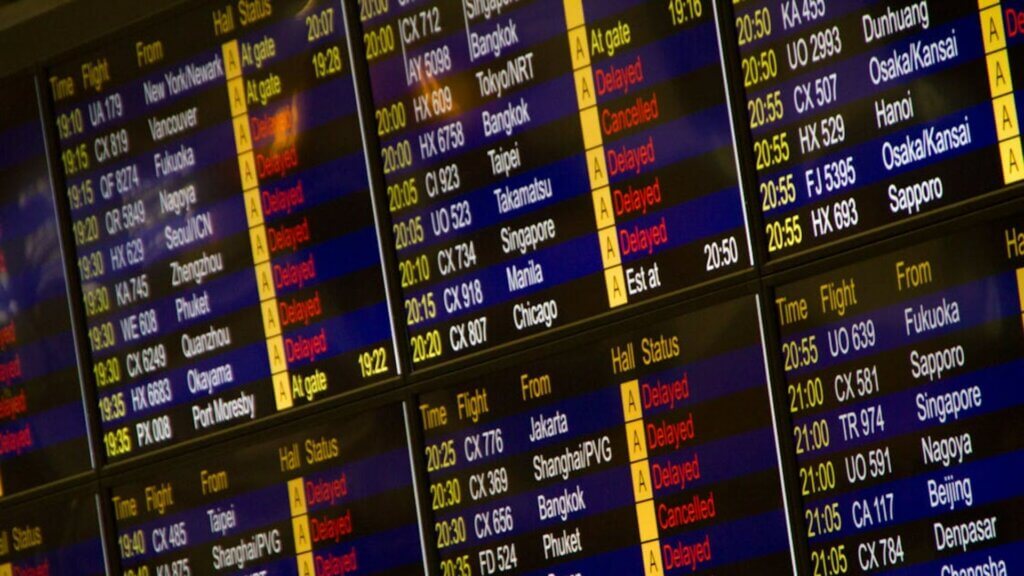Airport departure boards showing multiple domestic and international flights.