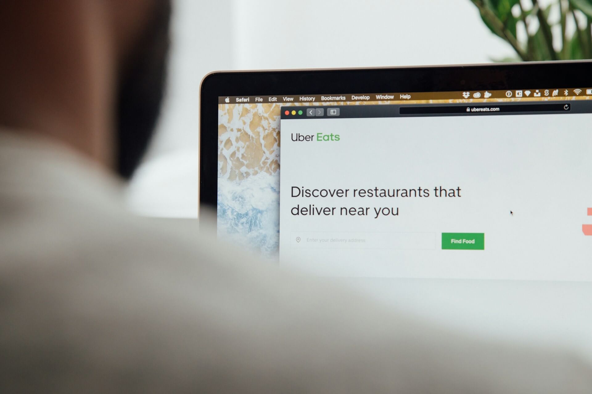 Person using a laptop displaying the Uber Eats website to browse nearby restaurant delivery options.