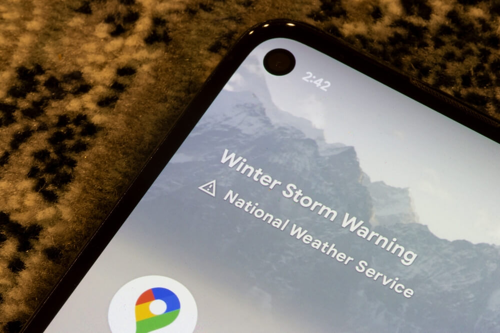 Smartphone screen displaying a National Weather Service winter storm warning alert.
