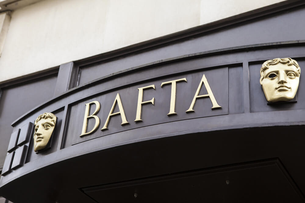 BAFTA sign and mask emblems displayed above the entrance of a building.