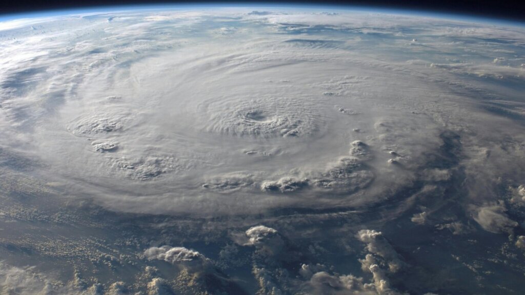 Hurricane viewed from space showing large swirling storm system over Earth.
