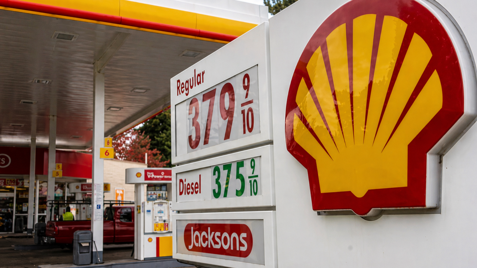 A close-up of a Shell gas station sign at a Jacksons food store; the digital prices for Regular gasoline and Diesel are displayed as $3.79 and $3.75 respectively, with a white SUV parked at a pump in the background.