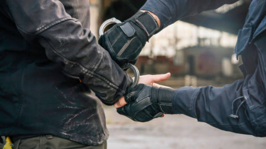 A close-up shot of two people’s hands in black tactical gloves.