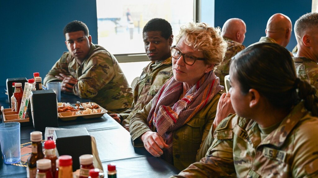 U.S. Army soldiers seated at a dining table with Representative Chrissy Houlahan of Pennsylvania speaking to them.