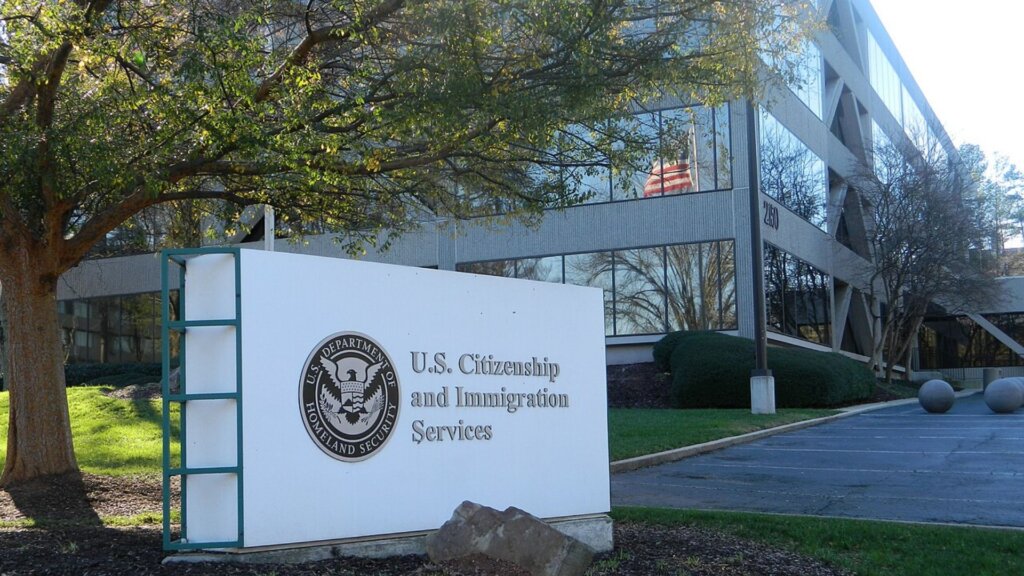 Sign for U.S. Citizenship and Immigration Services outside a government office building.