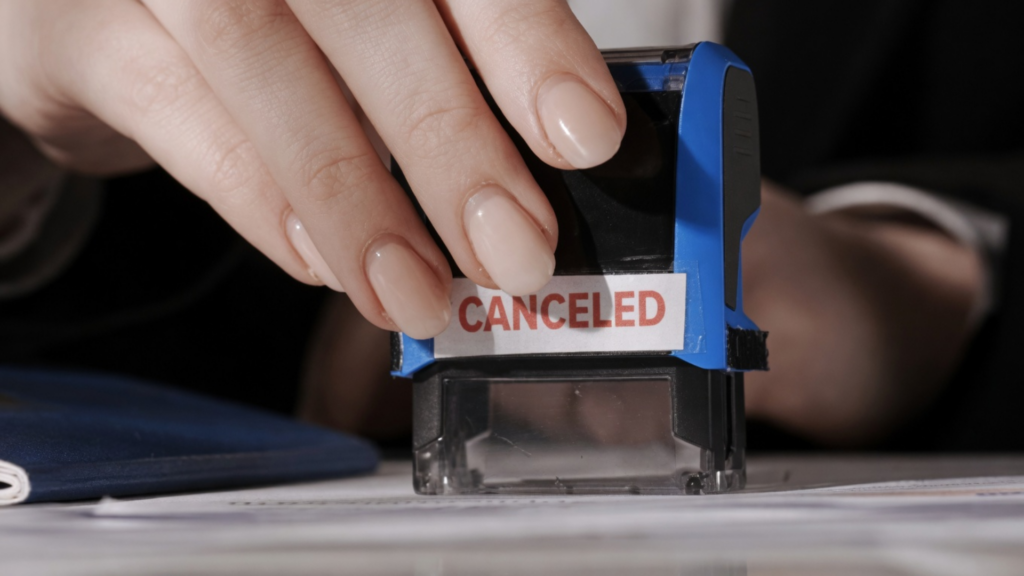 Hand stamping document with a red “Canceled” mark.