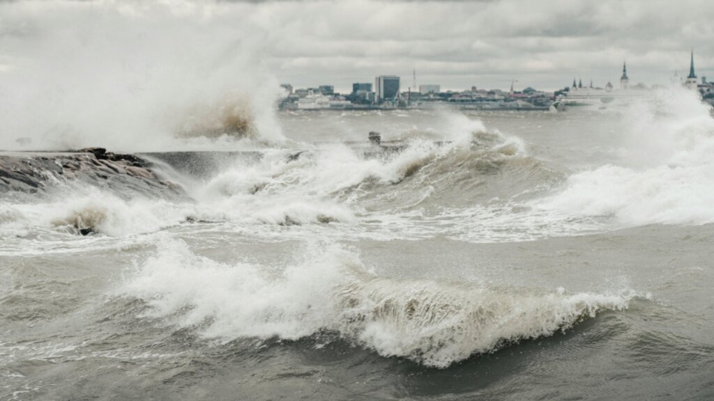 Large waves crashing during a storm along a coastal shoreline.