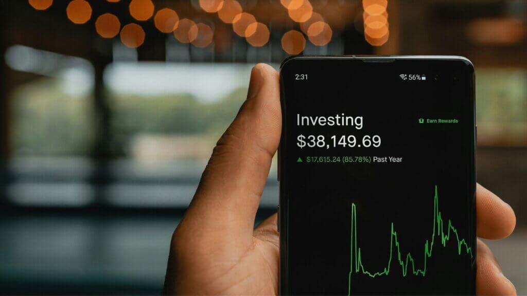 Smartphone displaying investment portfolio value and performance chart on screen.