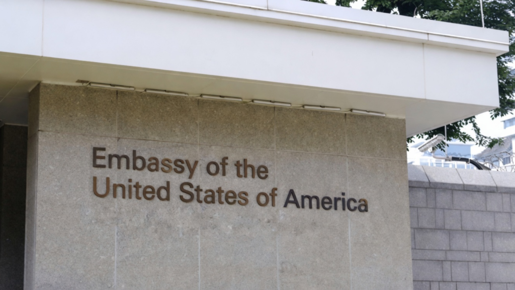 Sign reading “Embassy of the United States of America” on a building exterior.